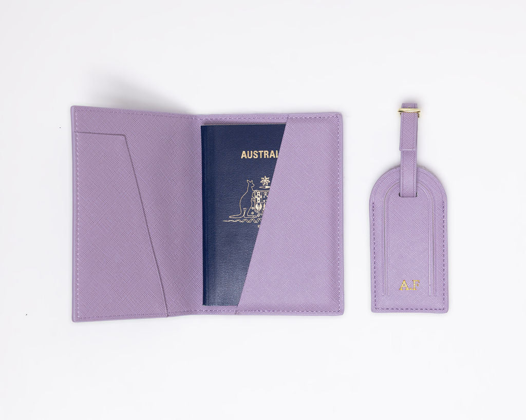 Open purple Saffiano leather passport holder with Australian passport inside, and a matching luggage tag.