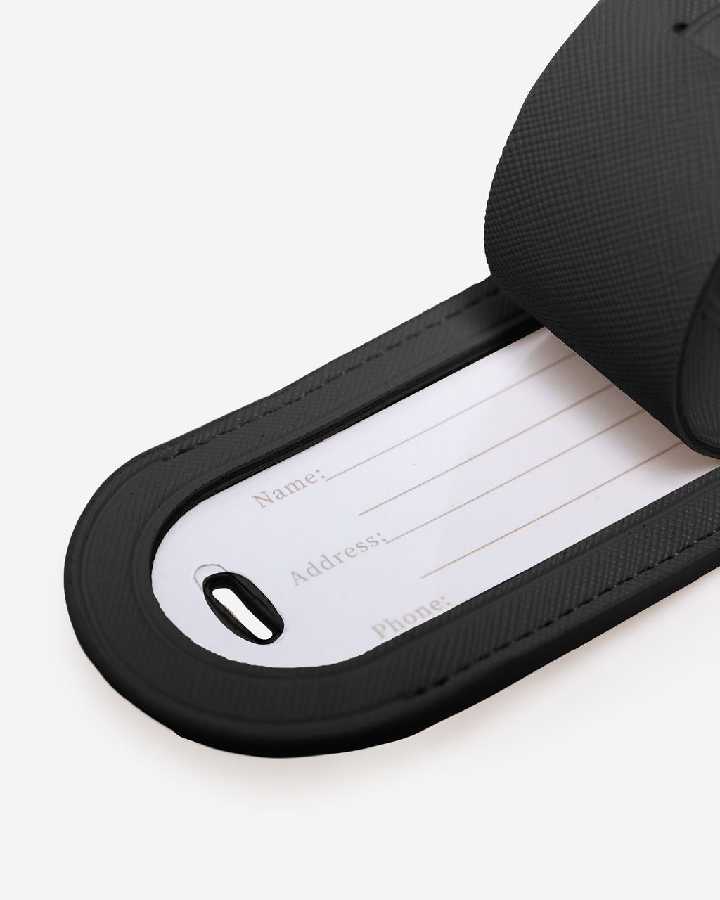 Close-up of open black Saffiano leather luggage tag revealing a blank white contact card for Name, Address, and Phone.
