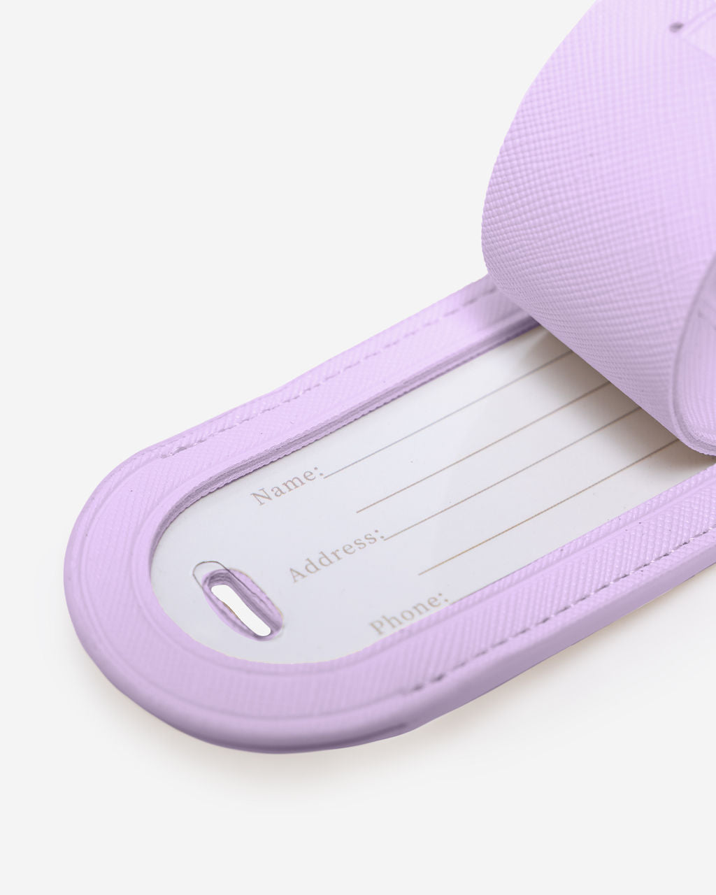 Close-up of a purple Saffiano leather luggage tag with the internal white card showing fields for Name, Address, and Phone.